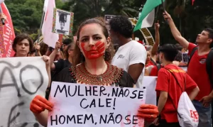 Mulher carrega cartaz durante protesto contra feminicidios